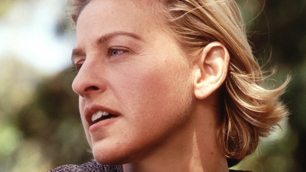 Ellen DeGeneres looking off to the side with a serious expression, while posing outside in 2000