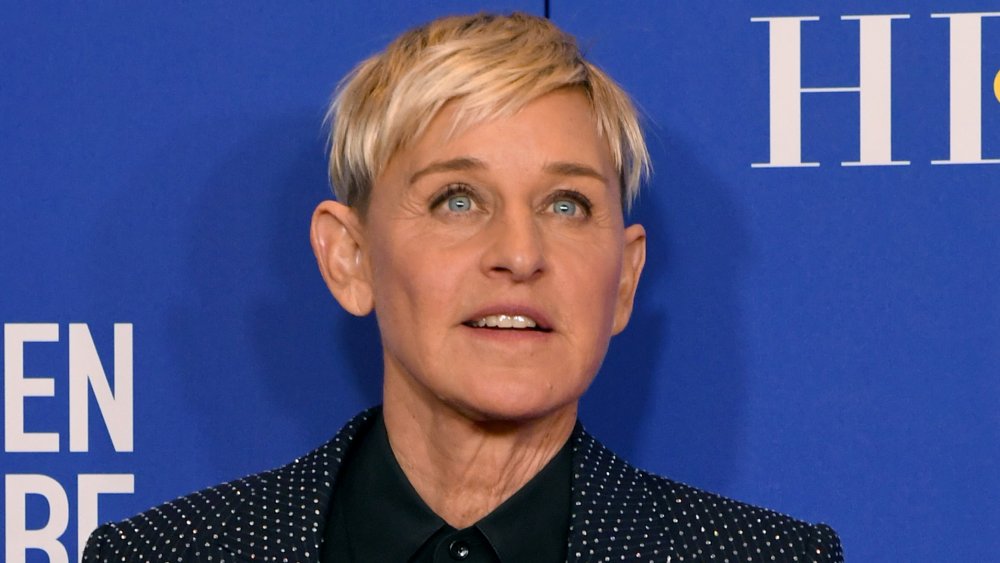 Ellen DeGeneres in a blue polka-dot suit and black shirt, posing with a neutral expression at the 2020 Golden Globes