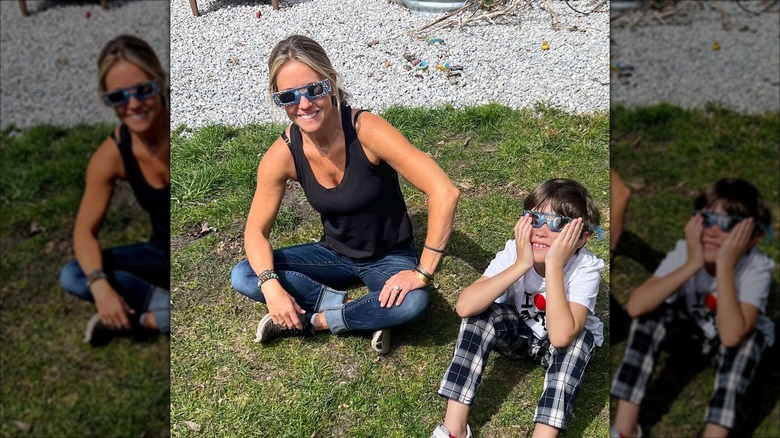 Wearing eclipse sunglasses, Nicole Curtis is all smiles while her son, Harper, looks at the sun.