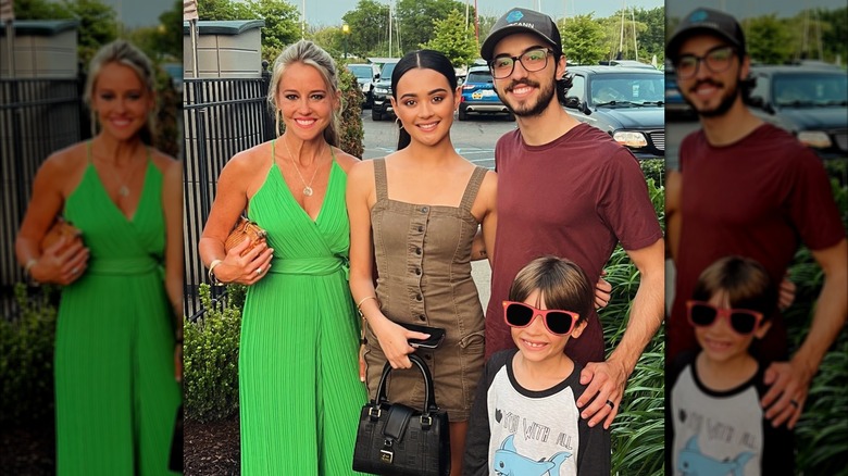 Nicole Curtis is all smiles while clutching a brown purse, as she stand's next to Ethan's girlfriend in a group photo.
