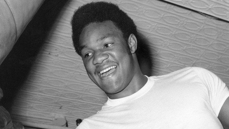 A young George Foreman wearing white t-shirt