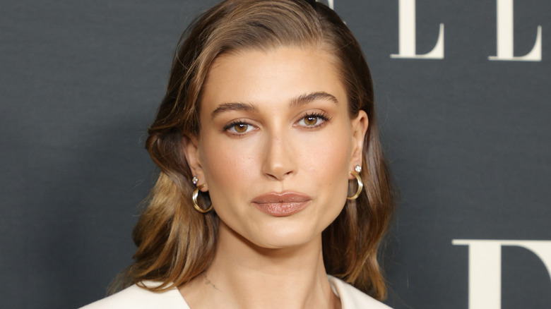 Hailey Bieber pouting gold earrings
