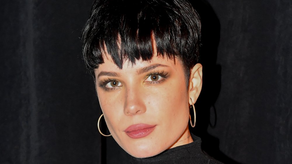 Halsey with short black hair and earrings