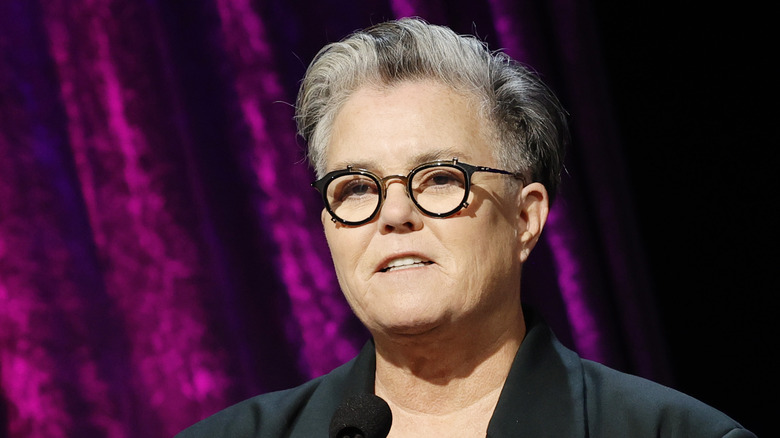 Rosie O'Donnell standing in front of a microphone
