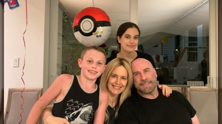 The Travolta family posing together in a house with Pokemon balloons.