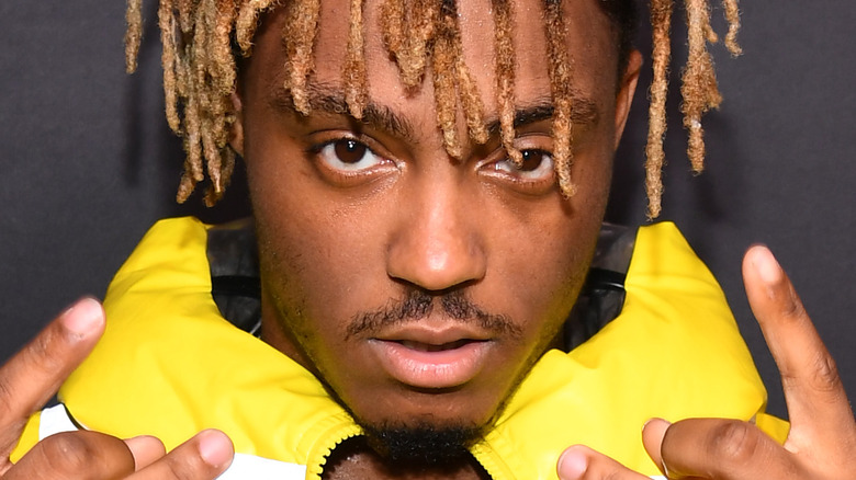 Juice WRLD looks at camera with hands raised