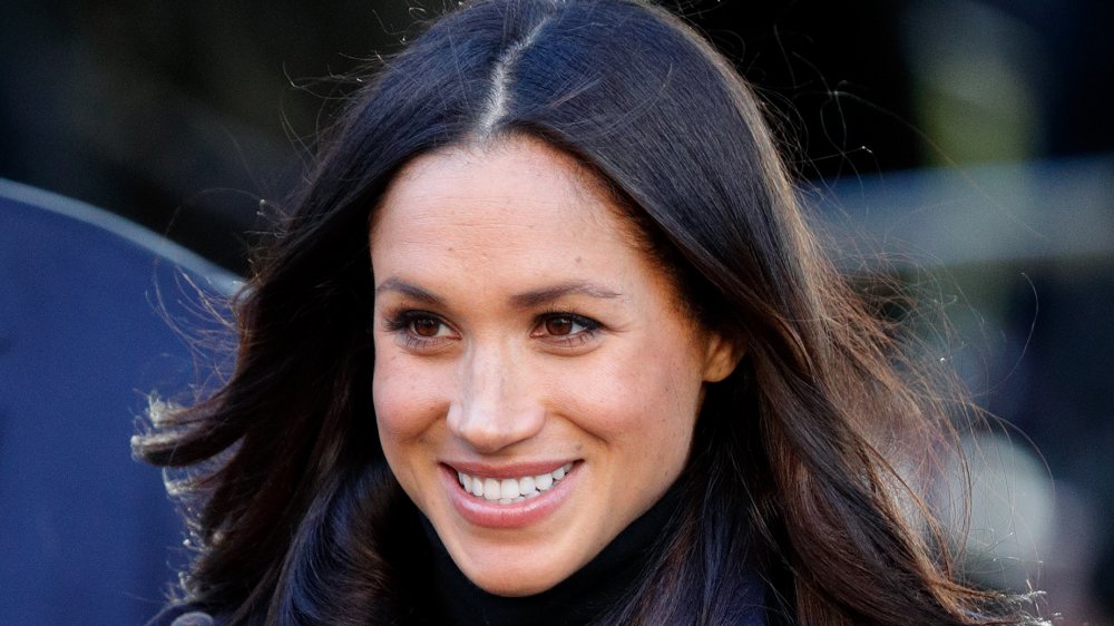 Meghan Markle smiling, head off to side