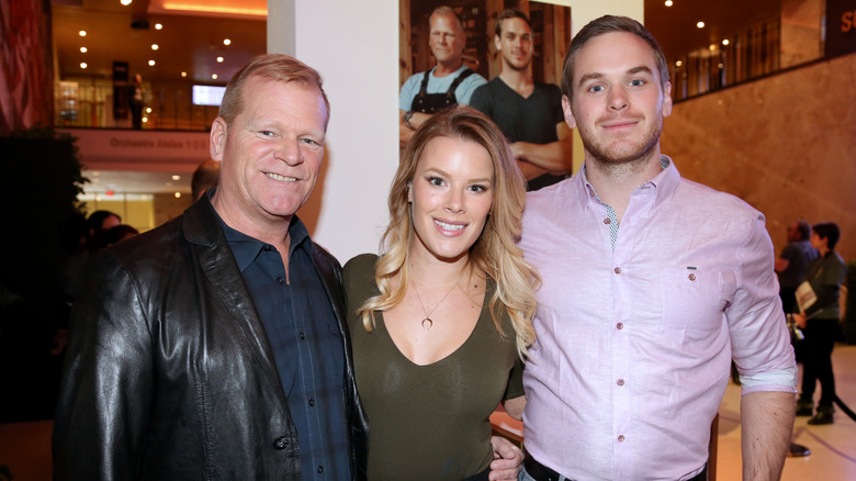 Mike Holmes, Sherry Holmes, and Mike Holmes Jr. posing at event