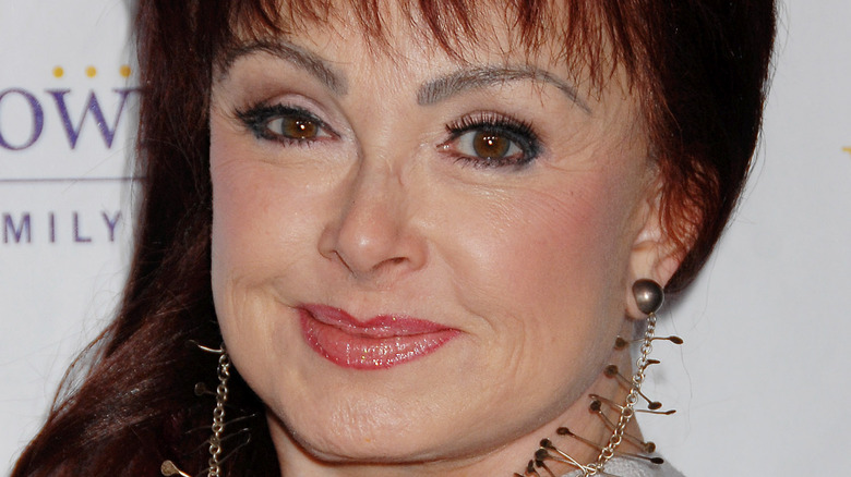 Naomi Judd wearing metallic earrings 