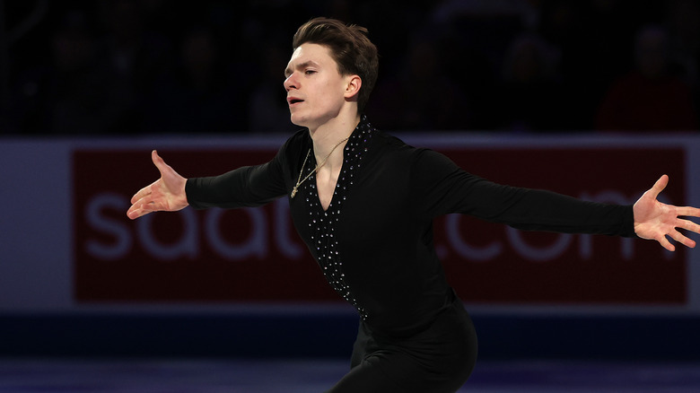Maxim Naumov skating on ice with his arms out