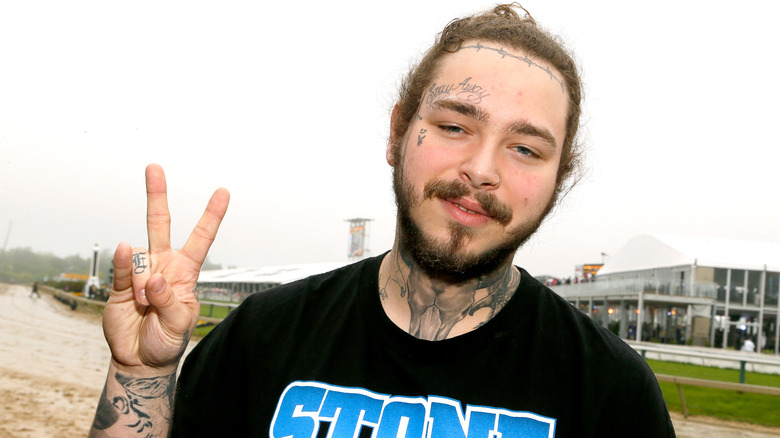 Post Malone holding up peace sign 