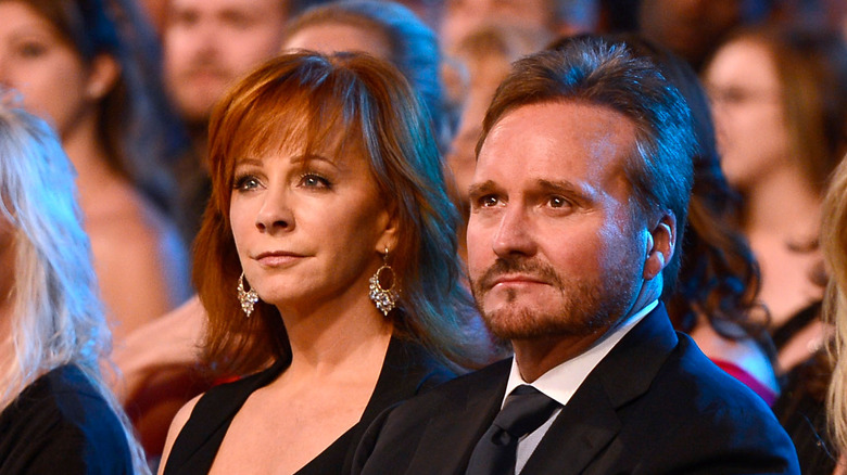 Reba McEntire and Narvel Blackstock looking afar while attending an event