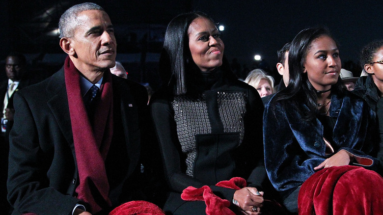 Sasha Obama sitting with her parents.