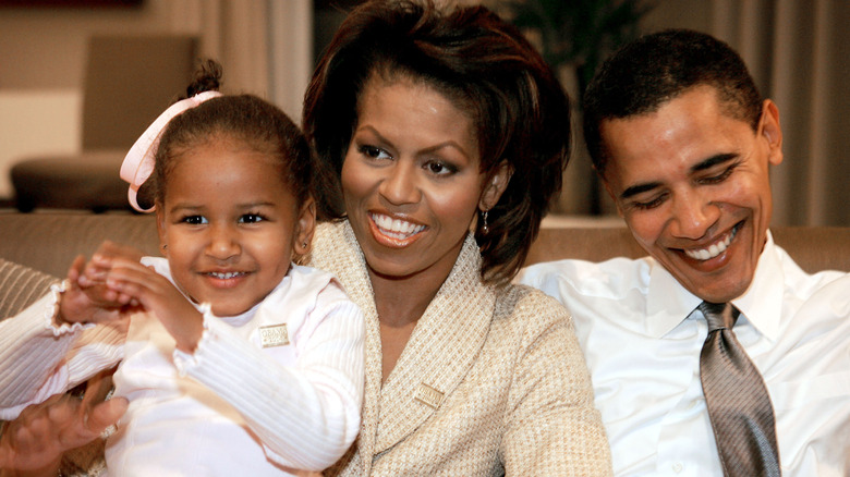 A young Sasha Obama pictured with her parents Michelle and Barack Obama.