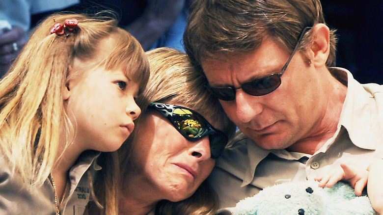 Bindi Irwin with her mother Terri crying and another family friend wearing sunglasses at Steve Irwin's funeral