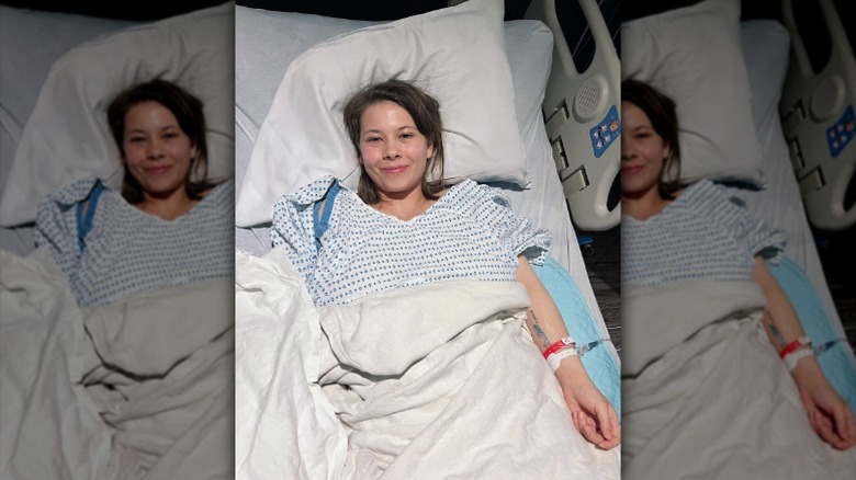 Bindi Irwin smiles from hospital bed afyer undergoing endometriosis surgery