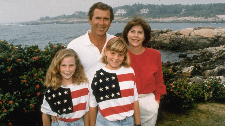 Jenna Bush with dad George W. Bush, mom Laura Bush, and sister Barbara Bush posing in front of rocky landscape