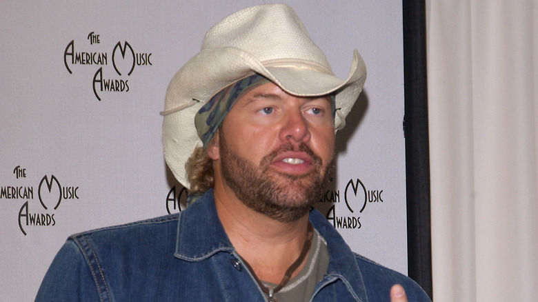 Toby Keith posing in white cowboy hat