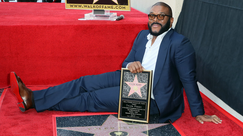 Tyler Perry smiling, with his star on the Hollywood Walk of Fame 