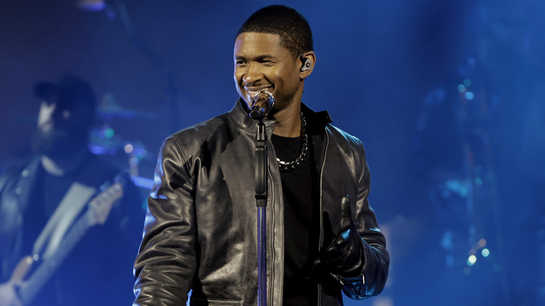 Usher preforming in black leather jacket