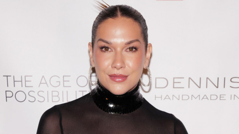 Allison Holker wearing a black mesh dress and hoop earrings