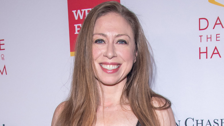 Chelsea Clinton smiling on step-and-repeat