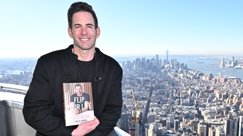 Tarek El Moussa posing with his book in his hand