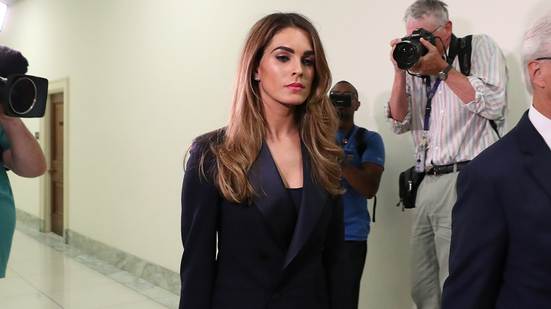 Hope Hicks walking past cameras with stern expression
