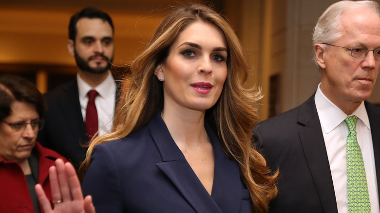 Hope Hicks smiling with her right hand up