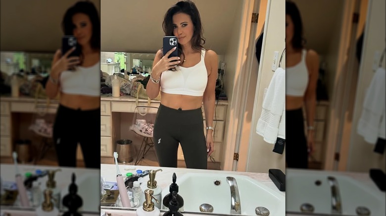 Julie Bidwell posing for a mirror selfie in workout clothes.
