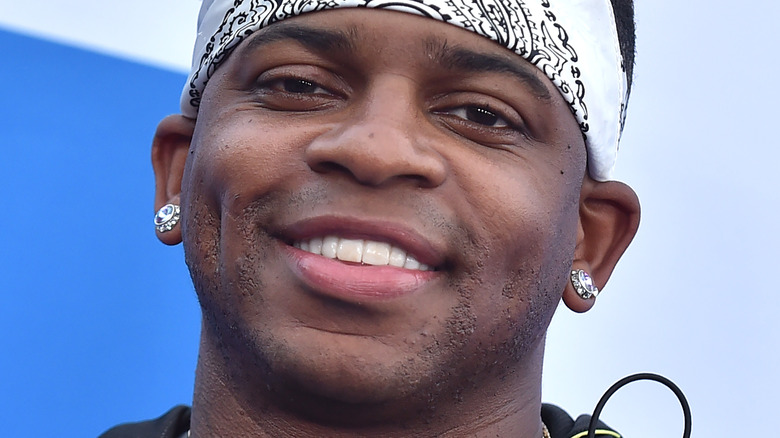 Jimmie Allen poses in white bandana. 
