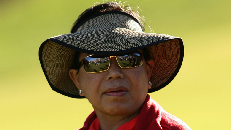 Kultida Woods wearing a hat and sunglasses