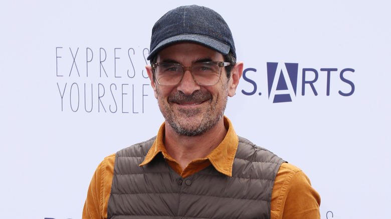Ty Burrell wearing cap and puffer vest on red carpet