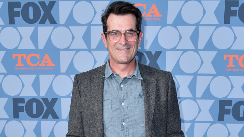 Ty Burrell wearing gray wool suit jacket on red carpet