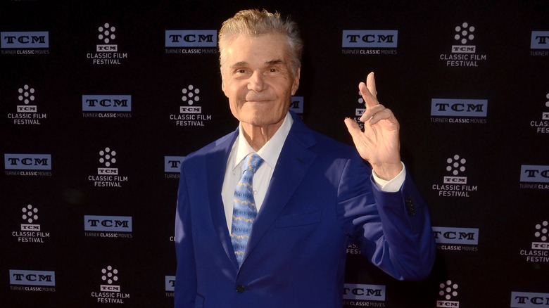 Fred Willard on red carpet wearing blue suit and tie
