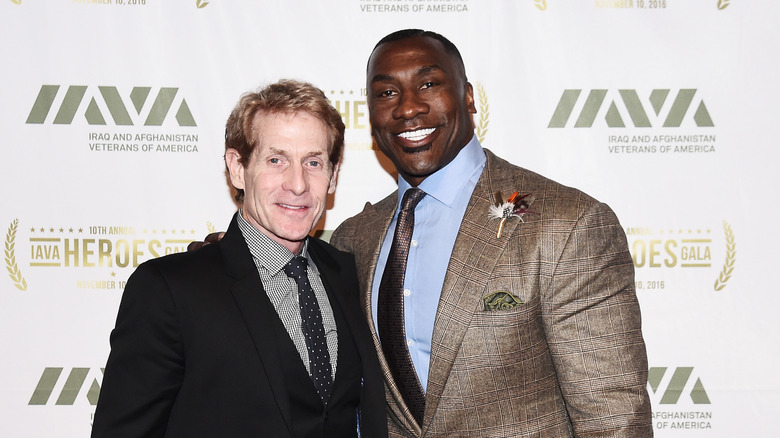 Skip Bayless posing with Shannon Sharpe on a red carpet