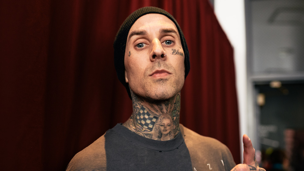Travis Barker wears a beanie and poses for a photograph