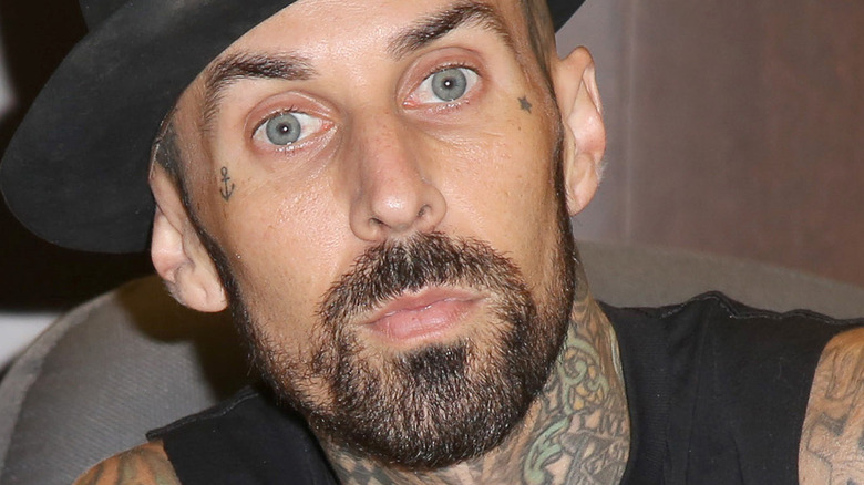 Travis Barker poses for camera in a hat