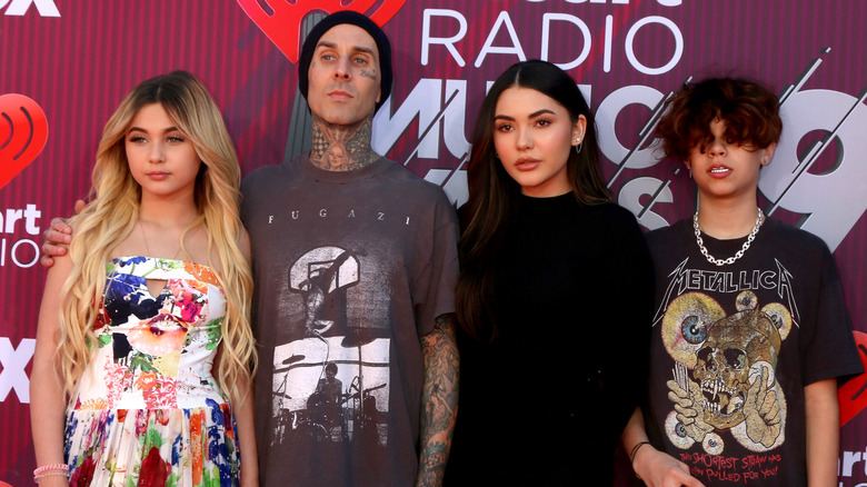 Travis Barker posing with children