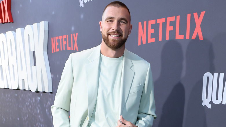 Travis Kelce smiling at red carpet event