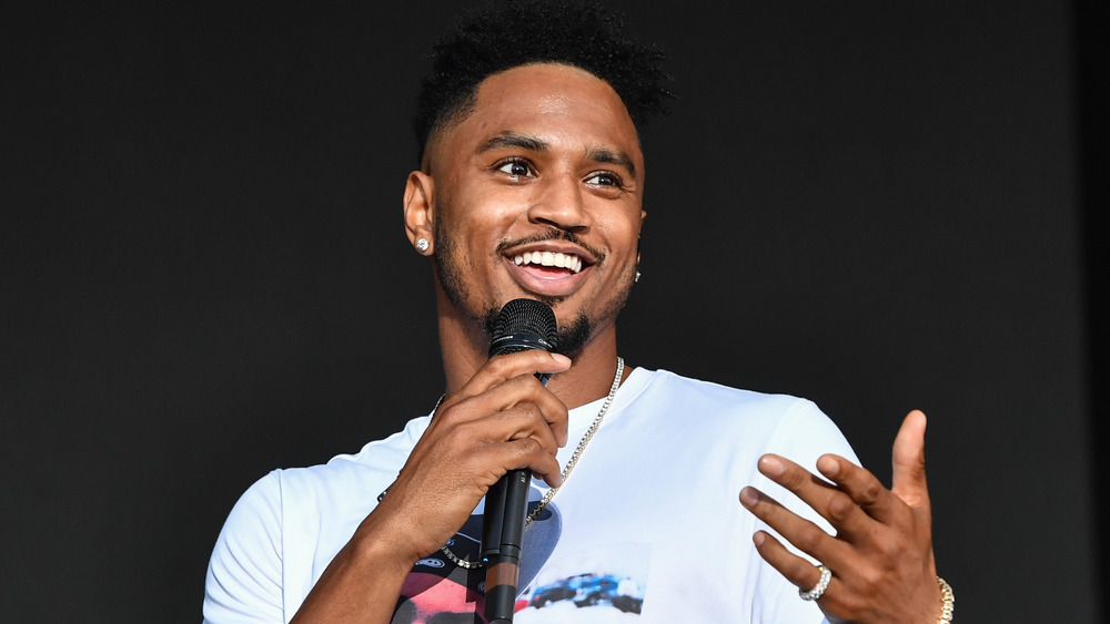 Trey Songz speaking with a microphone on stage