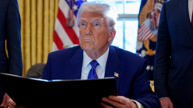 Donald Trump holding an executive order inside the Oval Office