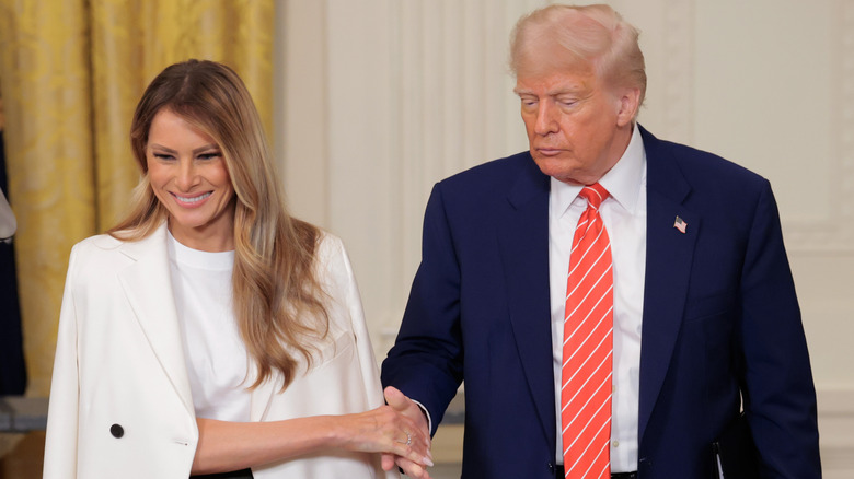 Melania Trump and Donald Trump touching hands