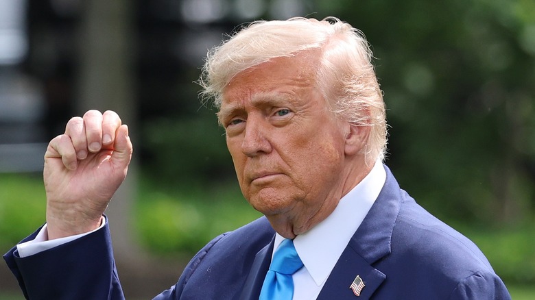 Donald Trump with bleached hair fist pumping at the cameras