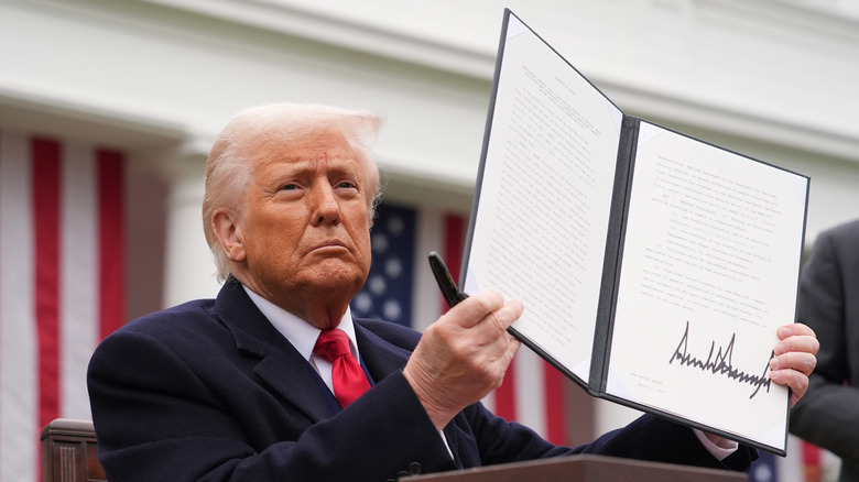 Donald Trump holding up signed executive order
