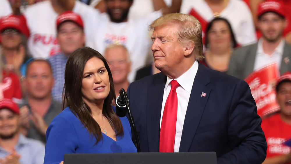 Donald Trump and Sarah Huckabee Sanders at podium