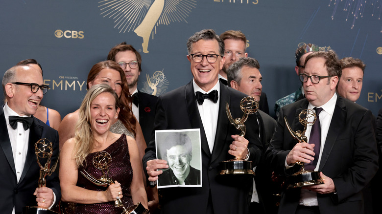 Stephen Colbert posing with his trophy