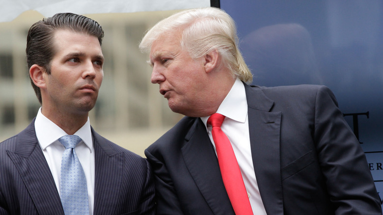 Donald Trump leans in to speak to Donald Trump Jr.