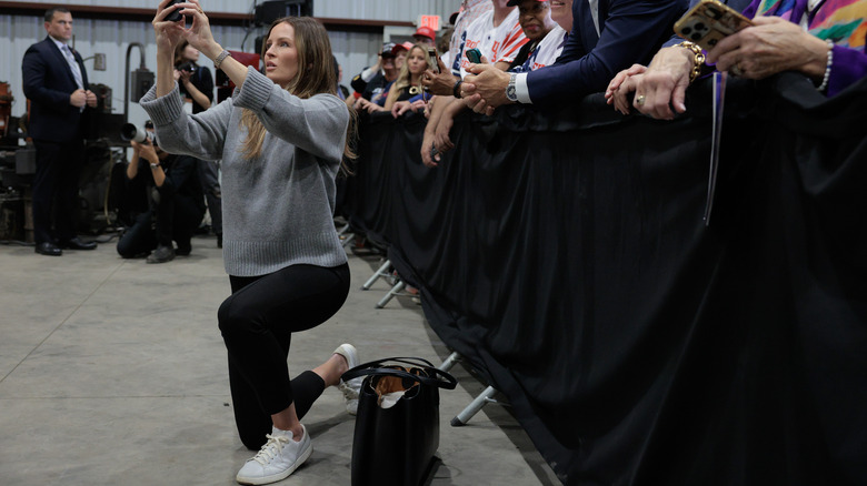 Margo Martin kneeling in sweater and black pants