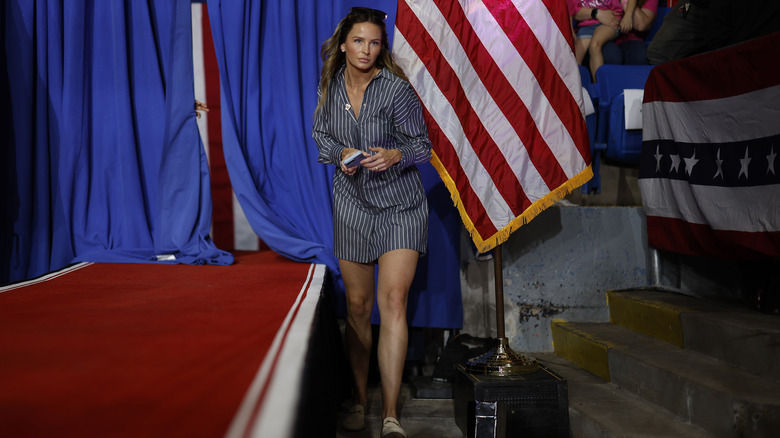 Margo Martin walking at rally in blue and white shirt-dress